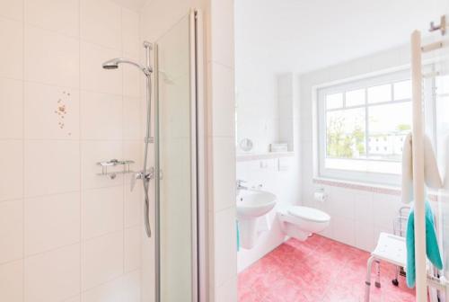 een badkamer met een douche, een toilet en een wastafel bij Villa Judith App. 3 Silbermöwe in Binz