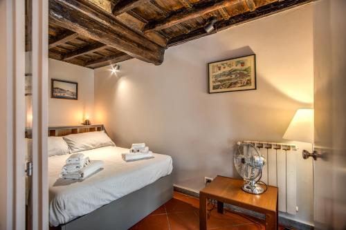 1 dormitorio con 1 cama y 1 mesa con ventilador en Cartari Apartment en Roma