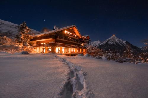 a large building in the snow at night at Auszeit-Hotel Z Aeschiried in Aeschi