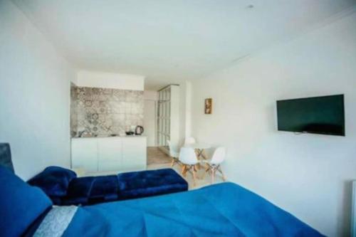 a bedroom with a blue bed and a flat screen tv at Ultra Lux in New Gudauri in Gudauri