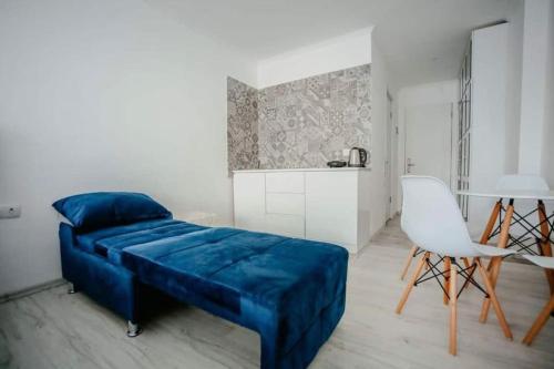 a bedroom with a blue couch and a white chair at Ultra Lux in New Gudauri in Gudauri