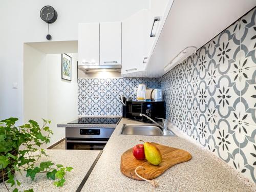a kitchen with a wooden cutting board with fruit on a counter at Gogol Studio Apartment in Budapest