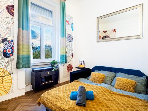 a bedroom with a bed with blue pillows on it at Gogol Studio Apartment in Budapest