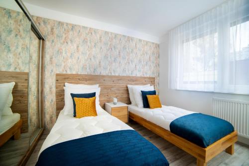 una camera da letto con due letti e una finestra di Comfort 18 Real Family Home a Miskolc