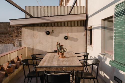 una mesa y sillas en un balcón con una planta en L'Olivera, Casa a Rupià, en Rupià