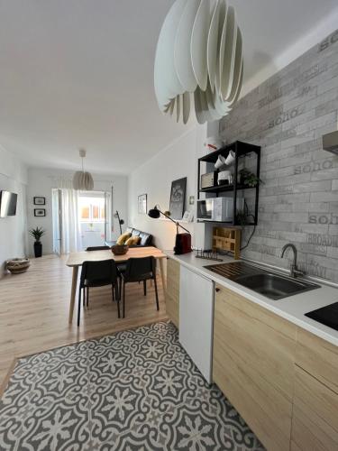 a kitchen with a table and a dining room at Teodósio - Ar condicionado-Perto Praias - Zona Central in Setúbal
