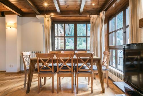 a dining room with a table and chairs and windows at Tulmas by Totiaran in Naut Aran