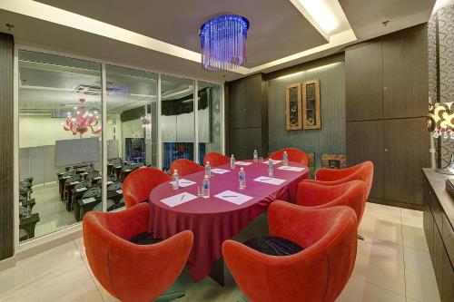 a dining room with a table and orange chairs at Arenaa Deluxe Hotel in Melaka