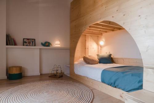 una camera con un letto e una parete in legno di L'Olivera, Casa a Rupià a Rupiá