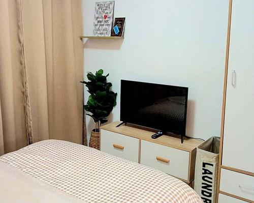a bedroom with a bed and a tv on a dresser at Dolores Residences Jesan Studio Unit in General Santos