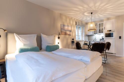 a large white bed in a room with a kitchen at Beach Lodge Beach Lodge Appartement 1 in Böhl