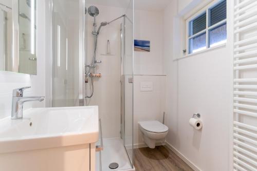 a bathroom with a shower and a toilet and a sink at Beach Lodge Beach Lodge Appartement 1 in Böhl