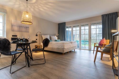 een slaapkamer met een bed en een tafel en stoelen bij Beach Lodge Beach Lodge Appartement 6 in Sankt Peter-Ording