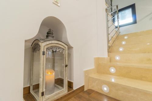 a lit candle in a glass case next to a staircase at Hotel Reina Aixa in Cogollos de Guadix