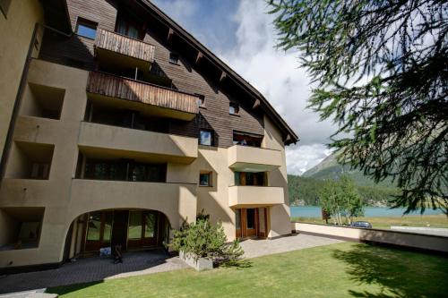 a large building with a lawn in front of it at Chesa Munteratsch 1-Zimmerwohnung 203 Typ B in Silvaplana