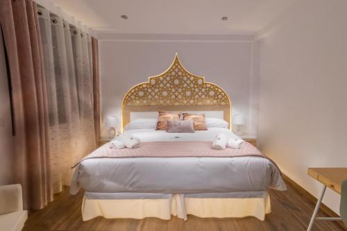 una camera da letto con un grande letto con una grande testiera di Hotel Reina Aixa a Cogollos de Guadix