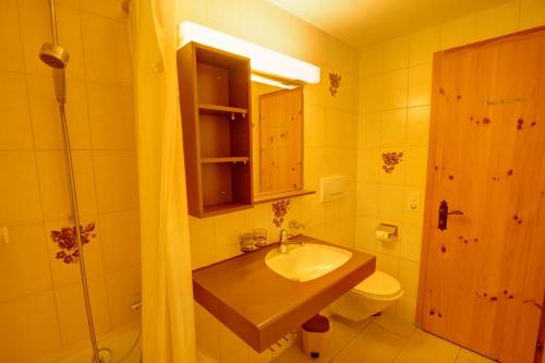 a bathroom with a sink and a toilet and a shower at Chesa Munteratsch 2-Zimmmerwohnung 205 Typ E in Silvaplana