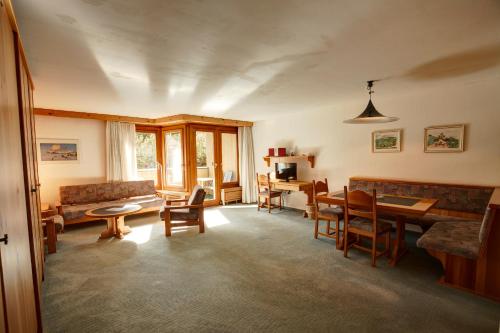 a living room with a couch and a table and chairs at Chesa Munteratsch 1 1 2-Zimmerwohnung 309 Typ C in Silvaplana