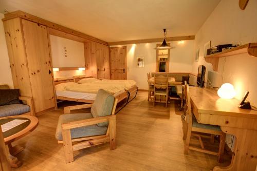 a bedroom with a bed and a table and chairs at Chesa Munteratsch 1-Zimmerwohnung 107 Typ B in Silvaplana