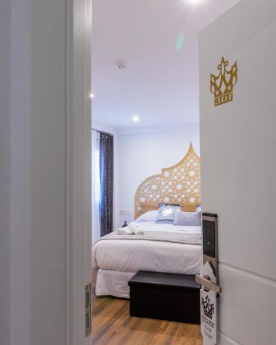 a bedroom with a bed and a door leading into a room at Hotel Reina Aixa in Cogollos de Guadix