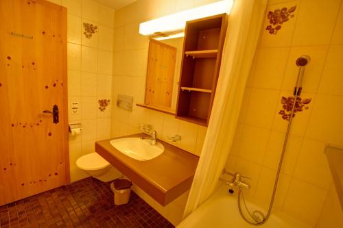 uma casa de banho com um lavatório, um WC e um chuveiro em Chesa Munteratsch 1 1 2-Zimmerwohnung 204 Typ D em Silvaplana
