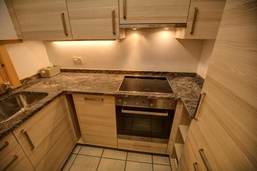 a small kitchen with a stove and a sink at Chesa Munteratsch 1-Zimmerwohnung 206 Typ B in Silvaplana