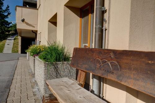 a wooden bench sitting in front of a building at Chesa Munteratsch 1-Zimmerwohnung 206 Typ B in Silvaplana
