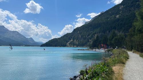 a body of water with mountains in the background at Chesa Munteratsch 1-Zimmerwohnung 206 Typ B in Silvaplana