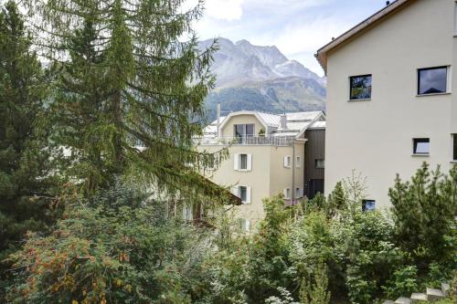 a view of a building with a mountain in the background at Chesa Munteratsch 1 1 2-Zimmerwohnung 409 Typ C in Silvaplana