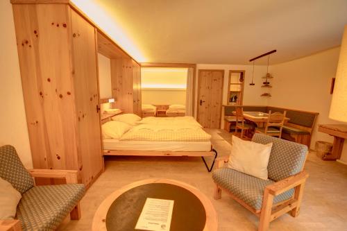 a bedroom with a bed and two chairs and a table at Chesa Munteratsch 1 1 2-Zimmerwohnung 209 Typ D in Silvaplana