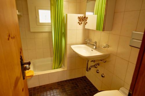ein Badezimmer mit einem Waschbecken, einem WC und einer Badewanne in der Unterkunft Chesa Munteratsch 1-Zimmerwohnung 411 Typ A in Silvaplana