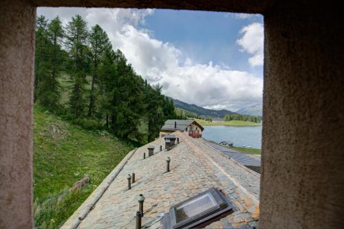 a view of a building on a pier next to a lake at Chesa Munteratsch 1 1 2-Zimmerwohnung 209 Typ D in Silvaplana
