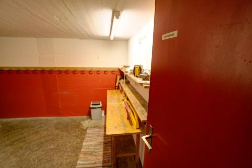 a room with a kitchen with a counter and red walls at Chesa Munteratsch 1 1 2-Zimmerwohnung 209 Typ D in Silvaplana