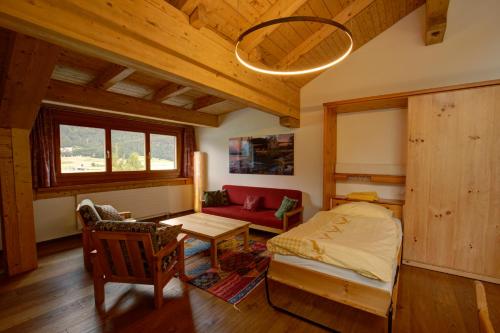 a bedroom with a bed and a red couch at Chesa Munteratsch 2-Zimmerwohnung 301 Typ E in Silvaplana