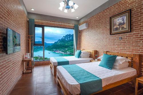 two beds in a room with a large window at Yosemite Riverview Homestay in Yichang