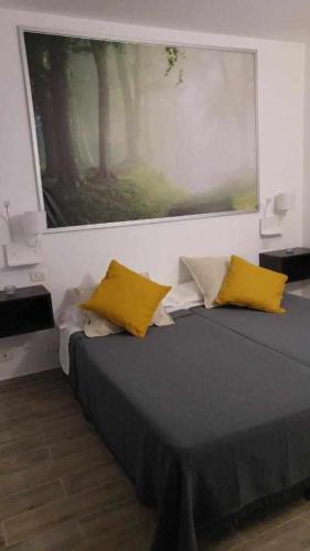 a bedroom with a bed with two yellow pillows at Chijere San Sebastián in San Sebastián de la Gomera