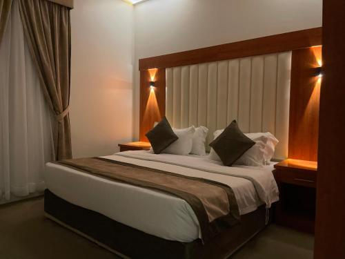 1 dormitorio con 1 cama grande con sábanas y almohadas blancas en Staytion Express Orjwan Lebanon, en Yeda