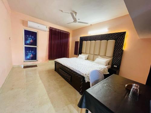 a bedroom with a large bed and a window at Hotel green park in Jabalpur