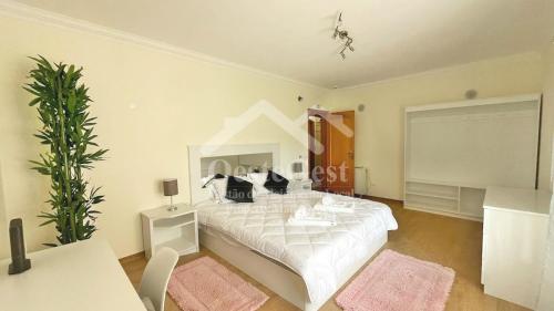 1 dormitorio con 1 cama blanca grande con almohadas negras en Villa Arrifes, en Reguengo Grande