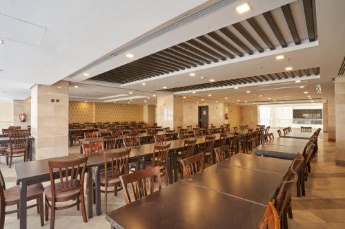 - un restaurant avec des tables et des chaises dans une salle dans l'établissement Al Hidayah Towers Hotel, à La Mecque