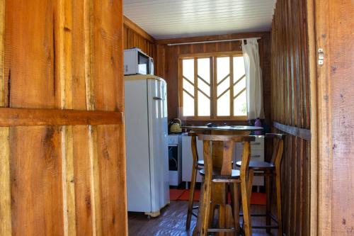 Una cocina con refrigerador y una mesa y sillas. en Cabana Casa do Lago, en Ilha Grande