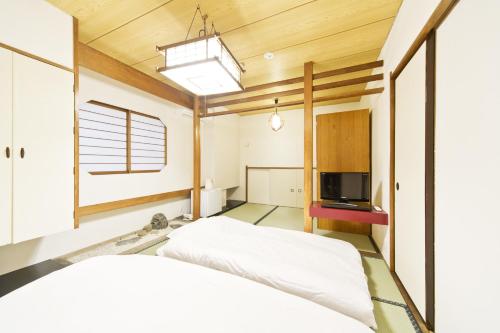 a bedroom with a bed and a television at Business Hotel Yamashiro in Tokyo