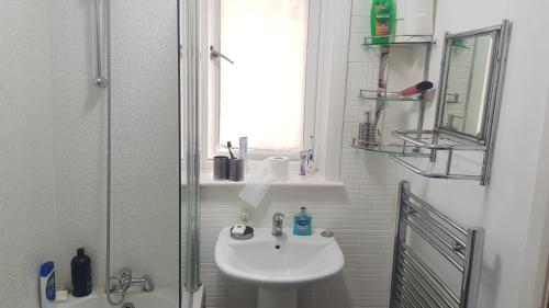baño blanco con lavabo y ventana en Double Bedroom In Withington, M20. 1 DB Bed, RM 1 en Mánchester