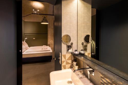 een badkamer met een wastafel, een spiegel en een bed bij grätzlhotel beim Belvedere in Wenen