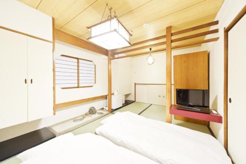 東京にあるビジネスホテル山城のベッドルーム(ベッド1台、テレビ付)