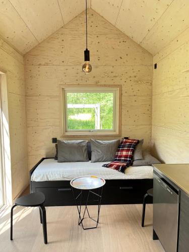 a bed in a room with a window and a table at Eljest Bed & Breakfast in Umeå