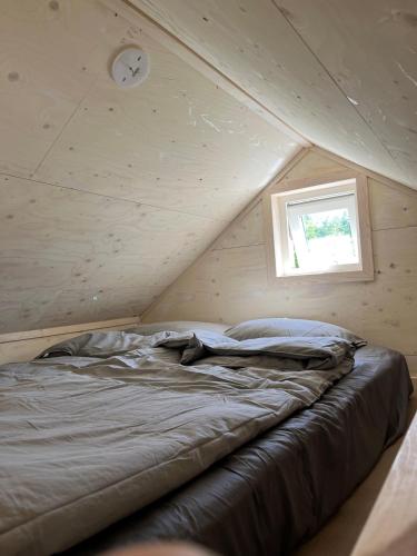 a bed in a attic with a window at Eljest Bed & Breakfast in Umeå