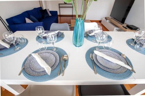 - une table blanche avec des assiettes et des verres à vin dans l'établissement Grand 3 pièces Créteil -20minutes de Paris !, à Créteil