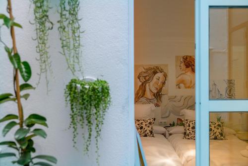 ein Zimmer mit Pflanzen und Gemälden an der Wand in der Unterkunft Eva Recommends Gamazo in Sevilla