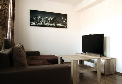 een woonkamer met een bank en een televisie op een tafel bij Apartmán Roosevelt in Banská Bystrica